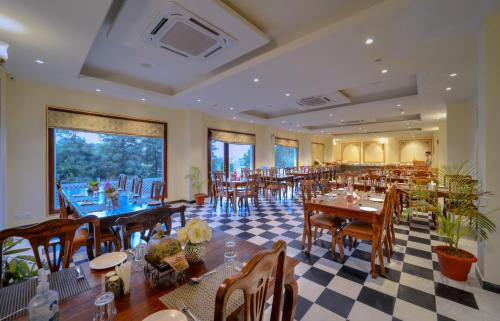 a restaurant with tables and chairs and a checkered floor at WelcomHeritage Mount Valley Resort Ranthambore in Sawāi Mādhopur