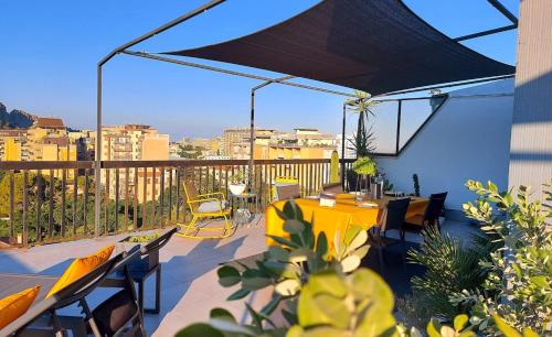 a patio with a yellow table and chairs on a balcony at Gebel Grin in Palermo