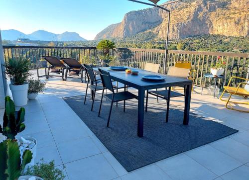 a black table and chairs on a patio with mountains at Gebel Grin in Palermo