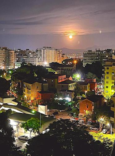 a view of a city at night with the moon at Gebel Grin in Palermo