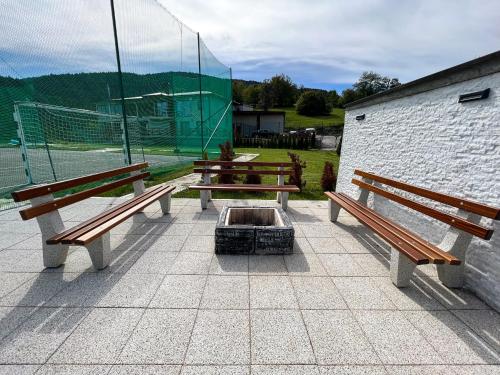 three park benches sitting next to a fire pit at Villa Sarajevo in Vareš