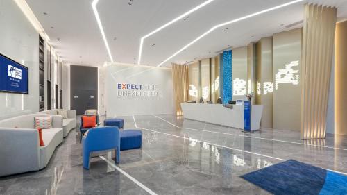 a lobby with chairs and a sign that reads expect the unexpected at Holiday Inn Express Changsha Kaifu by IHG in Changsha