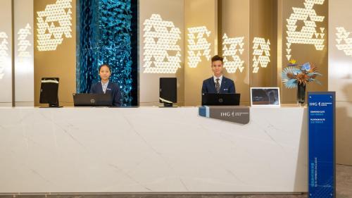 two men in suits sitting at a table with laptops at Holiday Inn Express Changsha Kaifu by IHG in Changsha