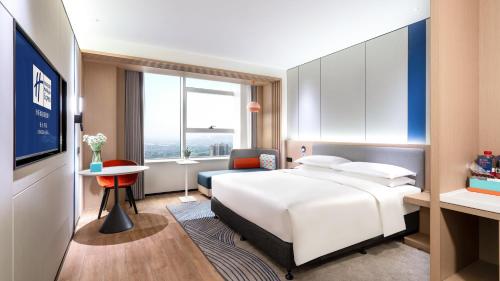 a hotel room with a white bed and a desk at Holiday Inn Express Changsha Kaifu by IHG in Changsha