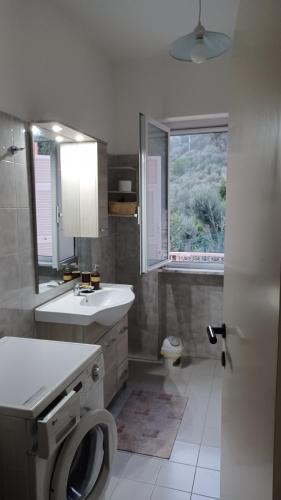a bathroom with a sink and a toilet and a window at Casa Melograno in Finale Ligure