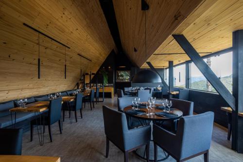 um restaurante com tectos e mesas e cadeiras de madeira em La Mansarda Hotel em Urubici