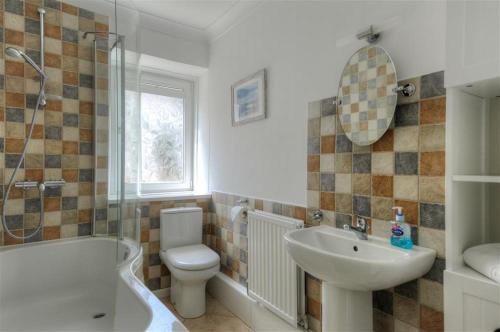 a bathroom with a sink and a toilet and a shower at Waterloo Place in Charmouth