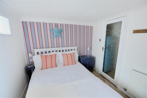 a bedroom with a white bed with two pillows at Waterloo Place in Charmouth