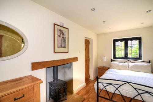 a bedroom with a bed and a fireplace at Yard Cottage in Lyme Regis