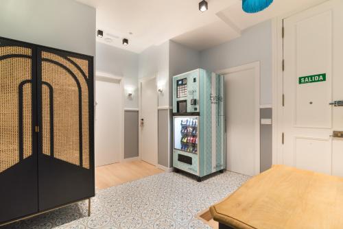 uma cozinha com um frigorífico aberto num quarto em Hostal Evoke Madrid em Madri