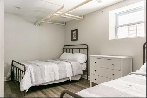 1 dormitorio con 2 camas, vestidor y ventana en Lovely Family Friendly Home- Free Parking, en Evanston