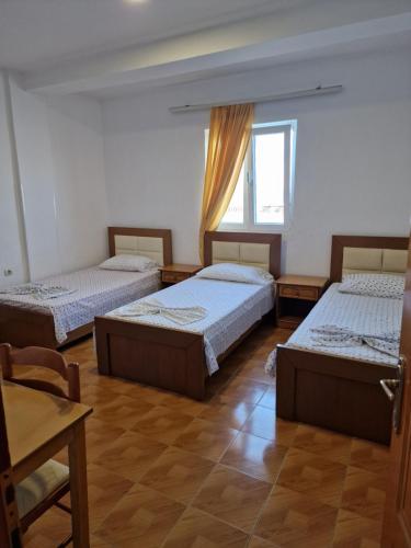 a room with three beds and a window at Hotel Restaurant Savoja in Pogradec