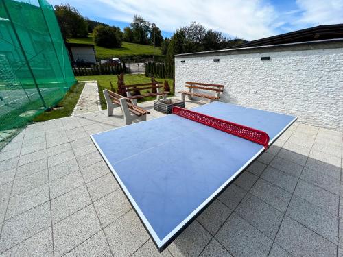 a ping pong table on a patio with two benches at Villa Sarajevo in Vareš