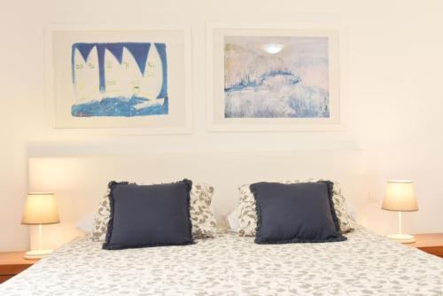 a bedroom with a bed with two pictures on the wall at Las Nasas, Acogedor apartamento cerca de la playa in Arinaga