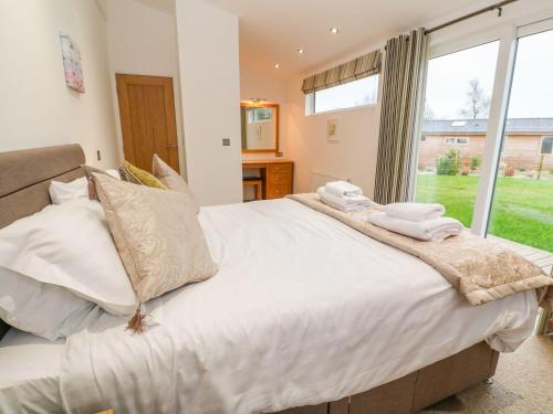 a large bed in a room with a large window at 12 Faraway Fields in Liskeard