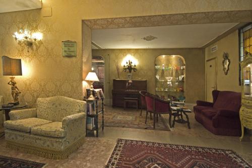 a living room with a couch a chair and a table at Hotel Bel Sito e Berlino in Venice