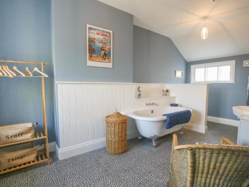 a bathroom with a bath tub and a sink at Gable Lodge in Great Malvern