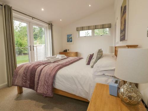 a bedroom with a large bed and a window at 11 Faraway Fields in Liskeard