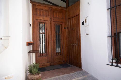 a wooden door in a hallway with a potted plant at Ático El Más allá in Chulilla
