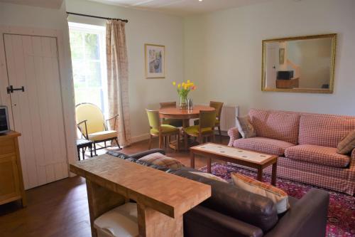 a living room with a couch and a table at Grooms Cottage in Carsethorn