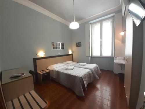 ein Schlafzimmer mit einem großen Bett und einem Fenster in der Unterkunft Albergo in Centro in Turin