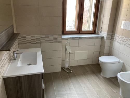 a bathroom with a sink and a toilet and a window at Dimora storica don Michele in Castelpagano