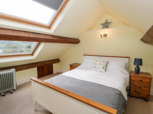 sypialnia na poddaszu z łóżkiem i oknem dachowym w obiekcie Wenallt w mieście Caernarfon