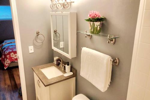 a bathroom with a sink and a mirror and a towel at Cheerful 3-BR home near Downtown Dayton, Wright Patterson AFB and Airport in Dayton