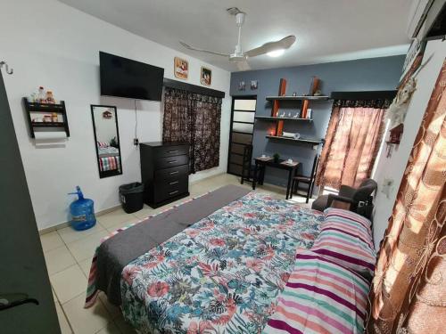 a bedroom with a bed and a television in it at Departamento independiente con todos lo servicios in Chetumal