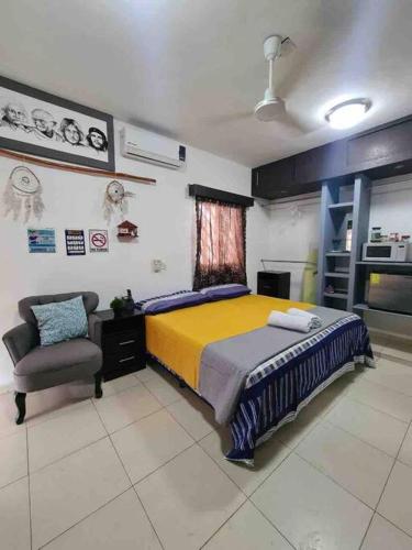 a bedroom with a bed and a chair in it at Departamento independiente con todos lo servicios in Chetumal
