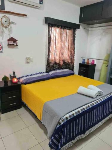 a bedroom with a bed with yellow and blue sheets at Departamento independiente con todos lo servicios in Chetumal