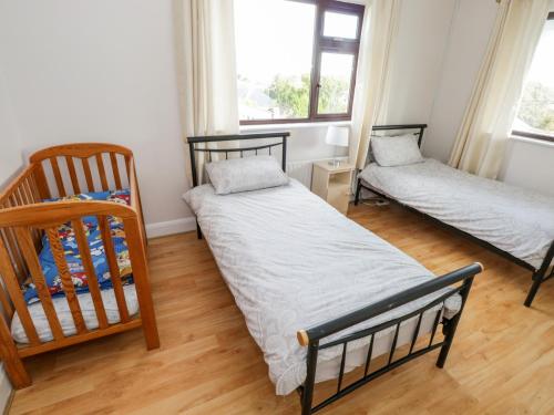 ein Schlafzimmer mit 2 Betten und einem Kinderbett in der Unterkunft Aras Iosgan in Carraroe