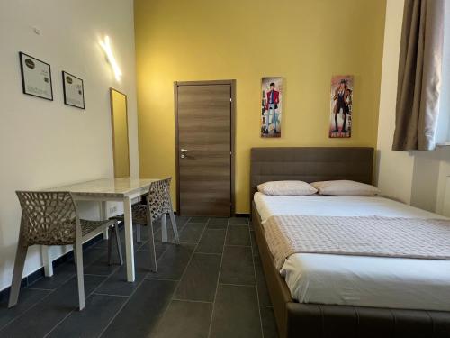 a bedroom with a bed and a table and a desk at Hostel Turin Metro Young in Turin