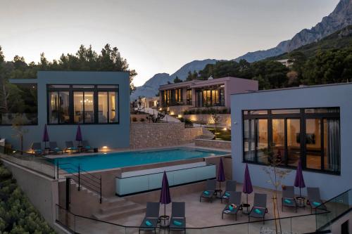 a villa with a swimming pool and a resort at Kuk Oaza Luxury Villas in Makarska