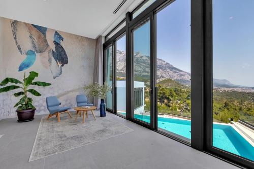 a living room with a view of the pool and mountains at Kuk Oaza Luxury Villas in Makarska