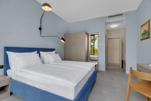 a bedroom with a blue and white bed and a desk at Kuk Oaza Luxury Villas in Makarska