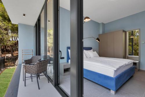 a bedroom with a bed and a balcony at Kuk Oaza Luxury Villas in Makarska