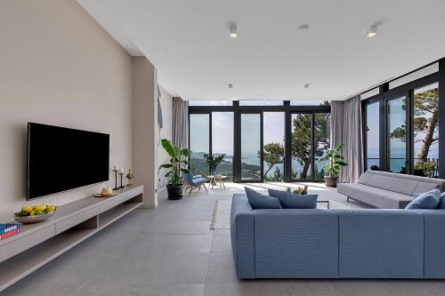 a living room with a blue couch and a tv at Kuk Oaza Luxury Villas in Makarska