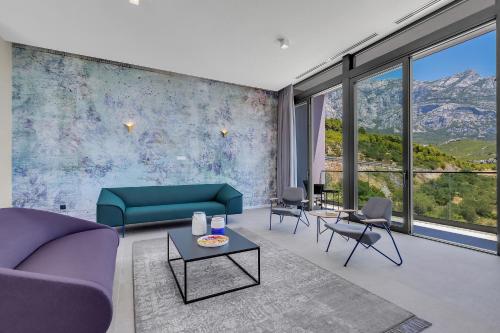 a living room with a couch and chairs and windows at Kuk Oaza Luxury Villas in Makarska