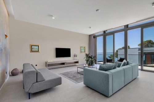 a living room with two couches and a television at Kuk Oaza Luxury Villas in Makarska