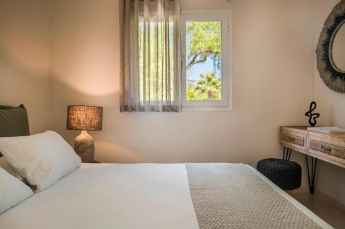 um quarto com uma cama branca e uma janela em Villa Thalassa Kefaloniaprivatevillas em Trapezaki