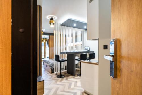 een kamer met een keuken met een tafel en stoelen bij Apartament Adasiowa Polana by Apart Concept Podhale in Kościelisko