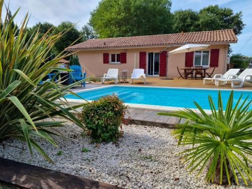 une villa avec une piscine et une maison dans l'établissement La Cabane au Carbet Piscine chauffée au calme dans la nature, à Sainte-Eulalie-en-Born