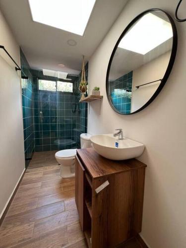 a bathroom with a sink and a mirror and a toilet at Amoblado cerca Centro eventos la Macarena NID203 By Roots Rentals in Medellín