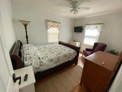 um quarto com uma cama, uma cadeira e uma mesa em Blues Bungalow em Pensacola