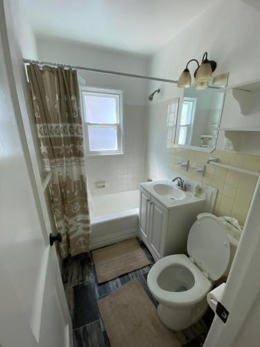 uma casa de banho branca com um WC e um lavatório em Blues Bungalow em Pensacola