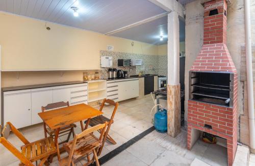 eine Küche mit einem Tisch und einem Steinofen in der Unterkunft Dona Rosa Suites Privativas in Arraial do Cabo