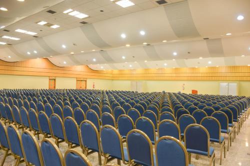 an empty lecture hall with blue chairs in it at Hotel Golden Park Internacional Foz & Convenções By Nacional Inn in Foz do Iguaçu