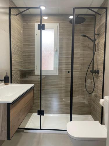 een badkamer met een douche, een toilet en een wastafel bij Apartamento Isabella suite in Güéjar-Sierra