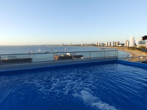 a swimming pool on top of a building with a view of the ocean at Tanger Hotel in Punta del Este